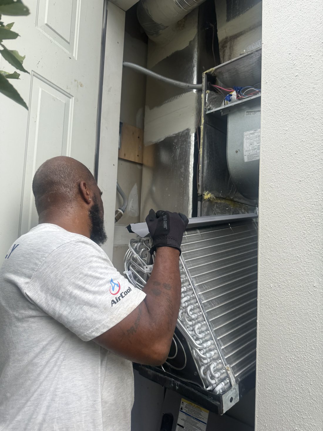 Cody Beauford pulling an evaporator coil out of an air handler